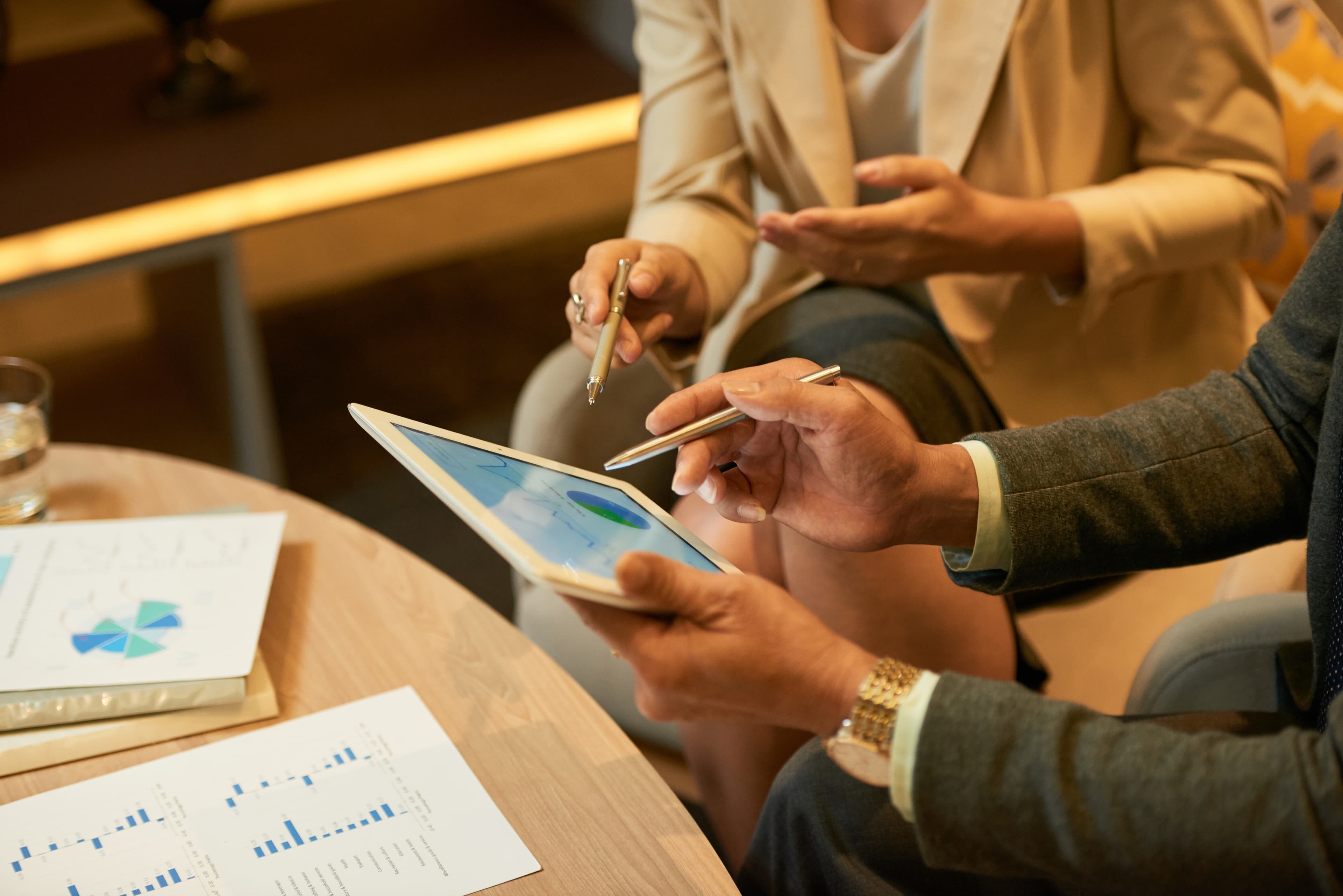 Réunion entre deux personnes étudiant un tableau de bord d'achats sur tablette