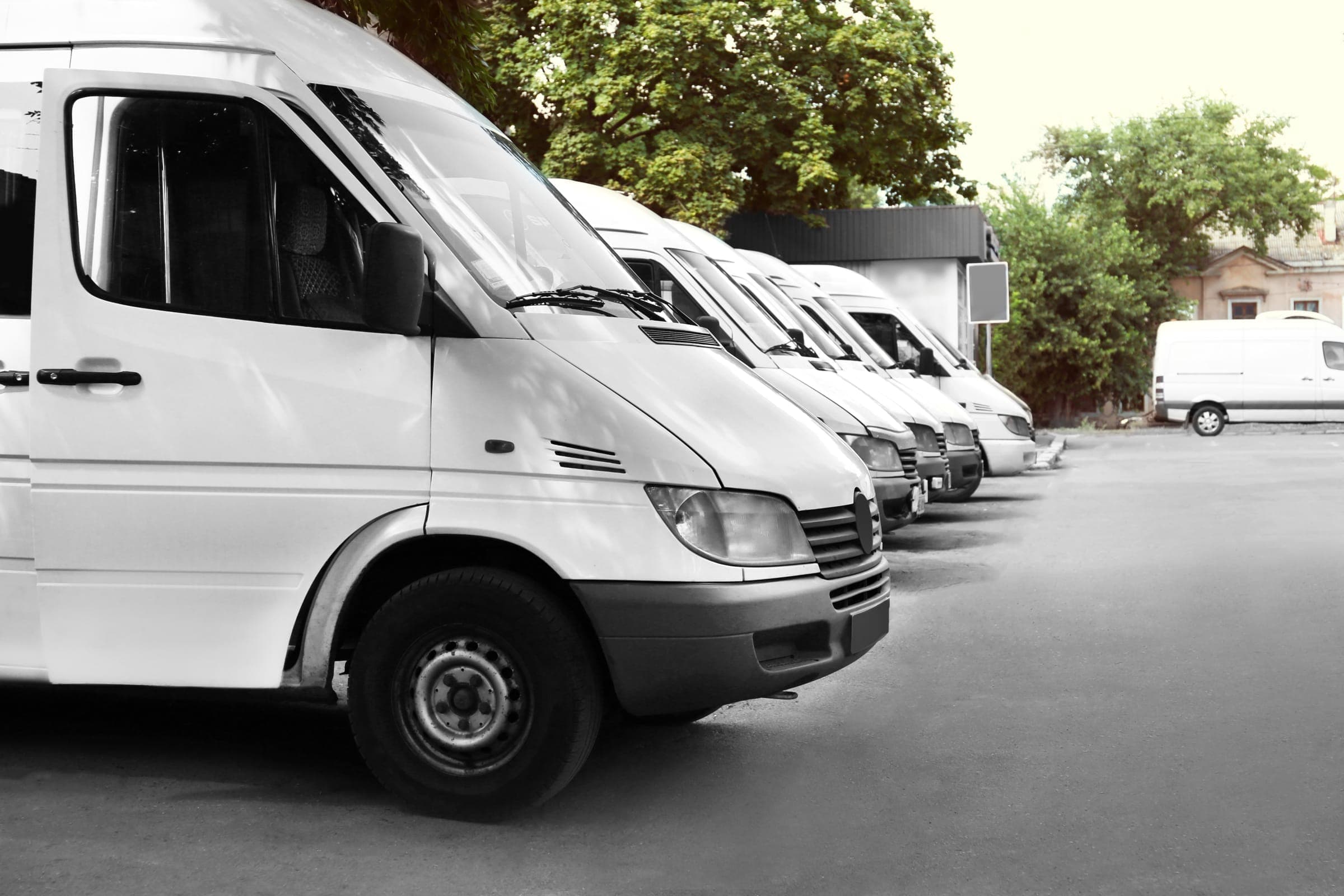 Flotte d'utilitaires blancs alignés — solutions d'attente OPTEAM+ LOC